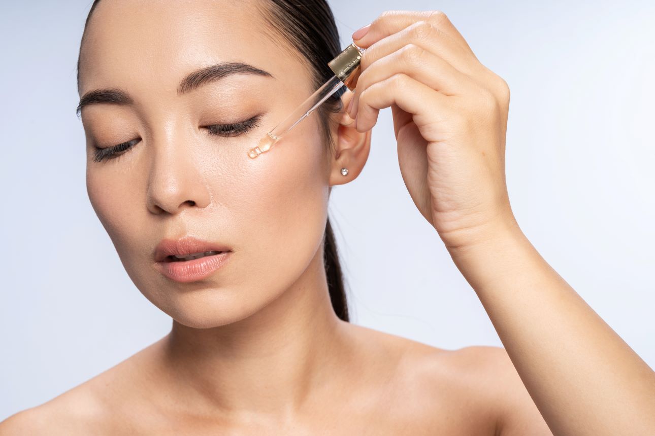 woman using a serum on her cheek