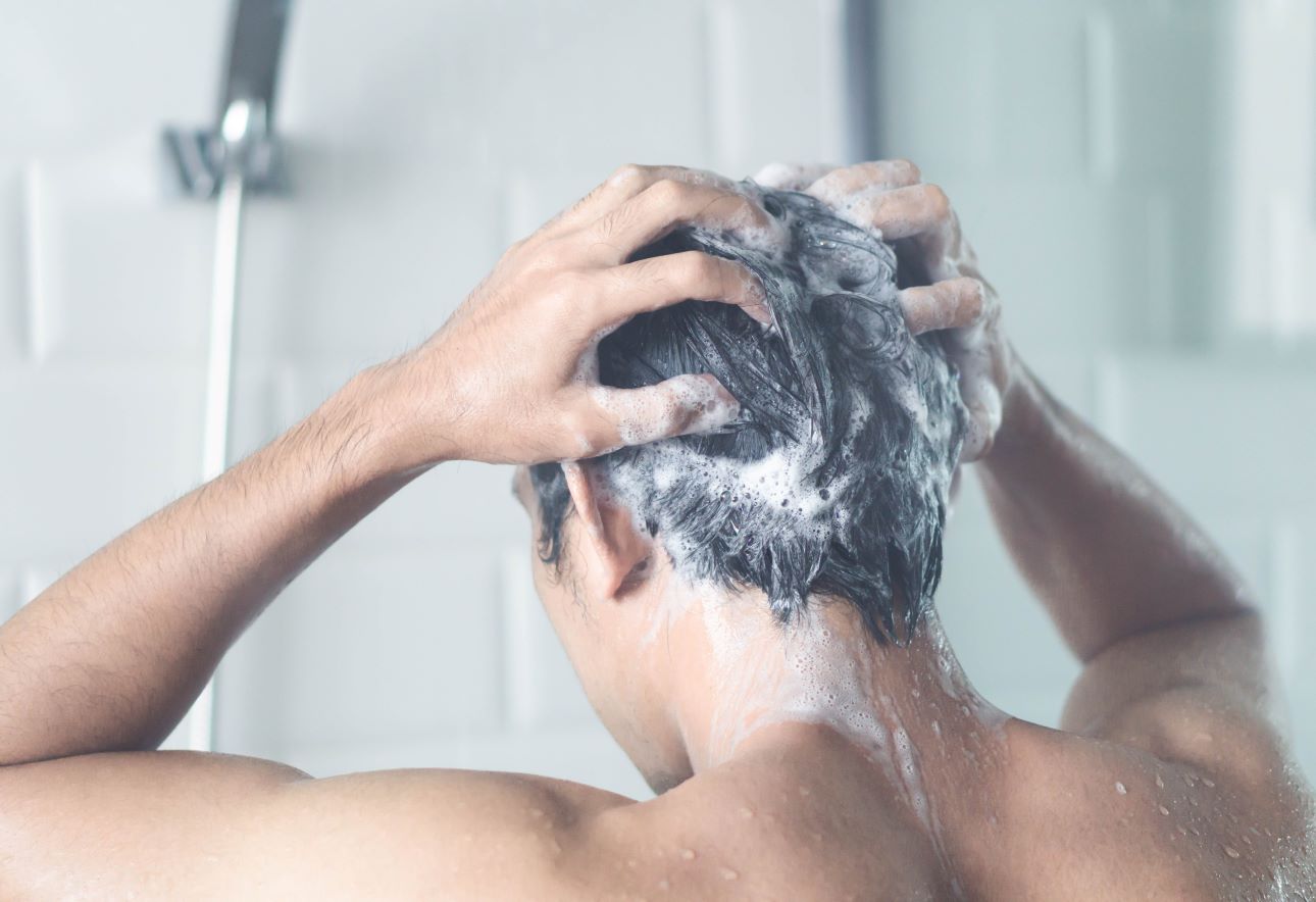 man in the shower washing his hair
