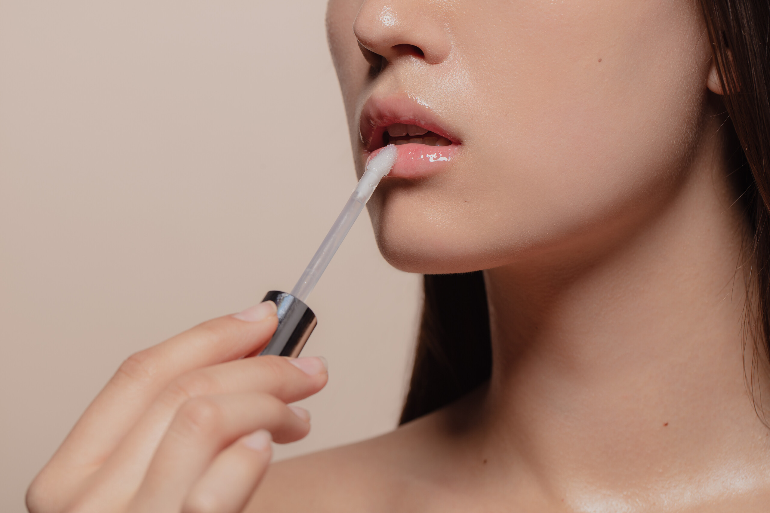 asian_woman_applying_clear_lipgloss